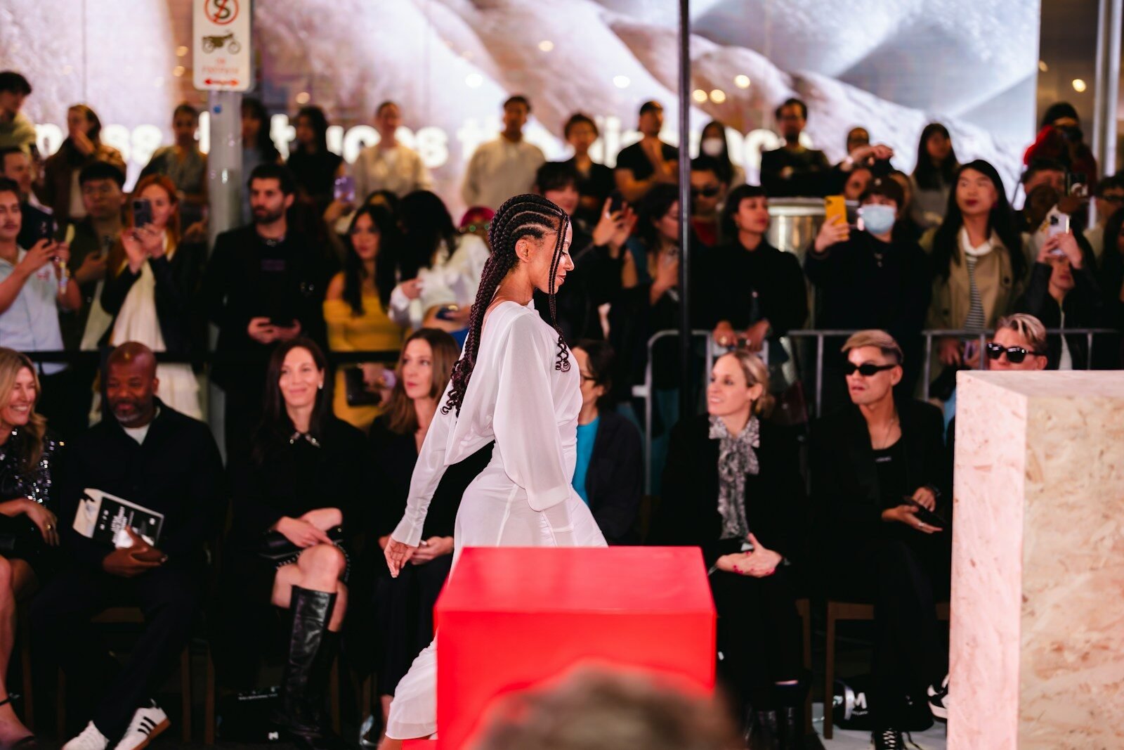 Model walks runway with audience watching