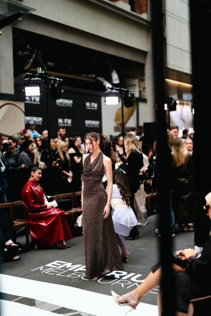 Model walks runway at fashion show event.