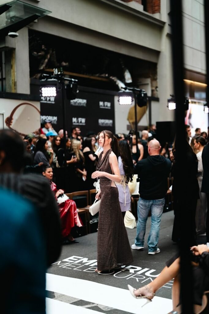 Model walks down a runway at a fashion show.