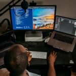 man in blue shirt using computer